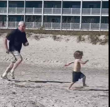 Pete Sutton chasing his grandson at the beach
