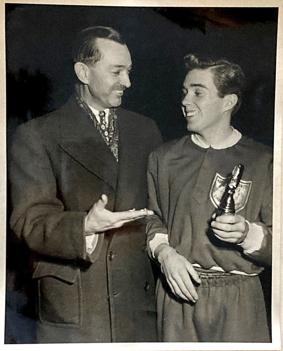 Pete Sutton in about 1948 with a trophy in his hand (on the right) and his father, Percy Sutton, on the left, beaming with pride, holding the medal in his open palm.
