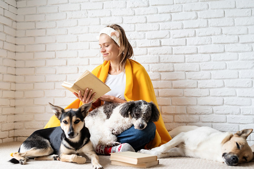 pet-care-funny-smiling-young-woman-yellow-plaid-sitting-with-her-dogs-reading-book.jpg