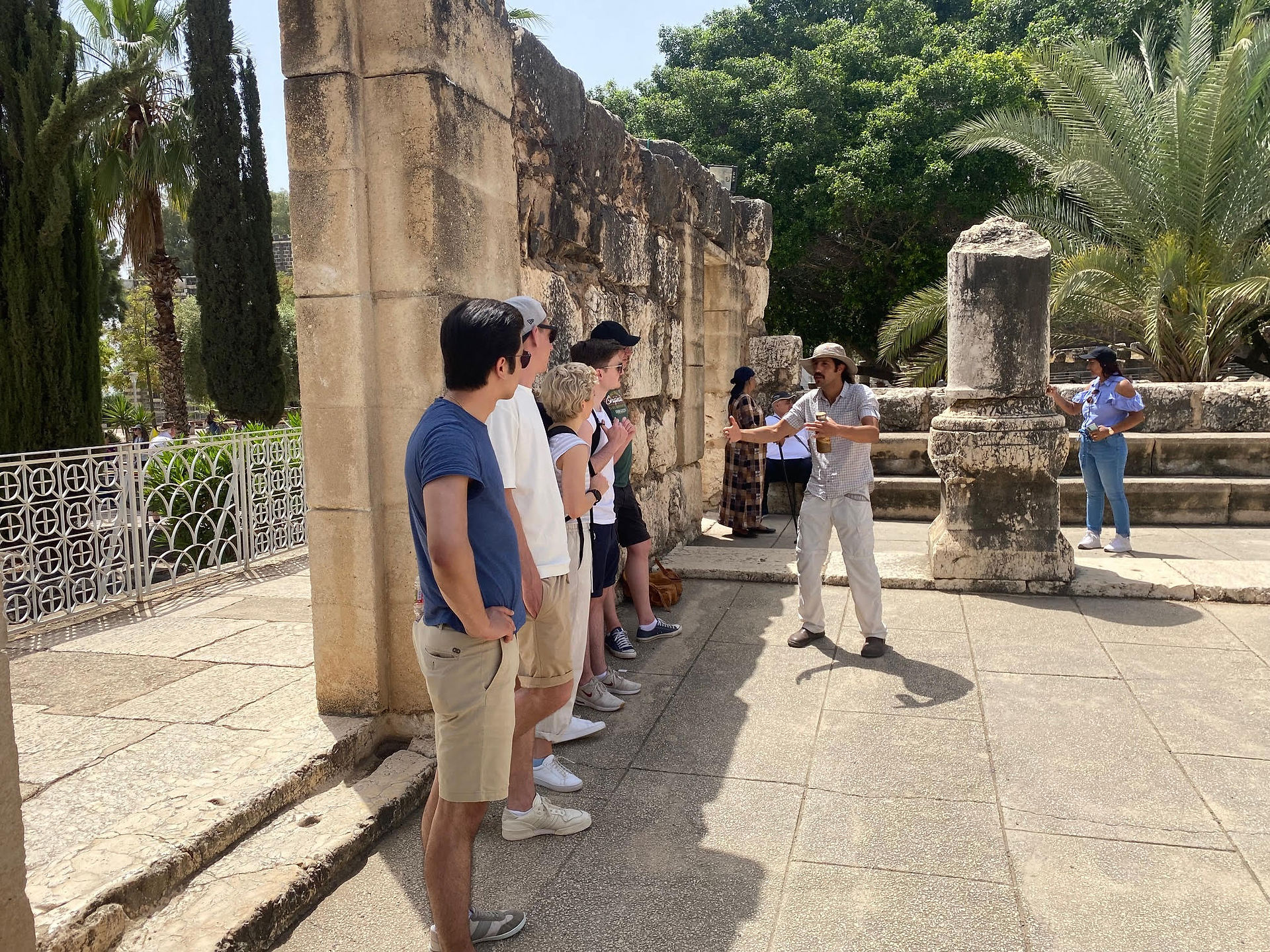 Sagi Levy, private tour guide, explaining the first-century synagogue ruins at Magdala to a group of travelers.