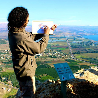 Private guide drawing a diagram to explain the battle history of the Sea of Galilee from a scenic lookout.