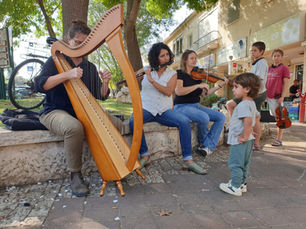 Street musicians playing harp and violin during a local arts festival, authentic cultural tours.