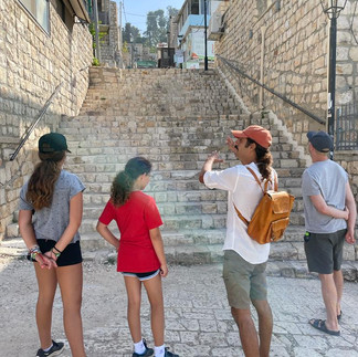 Private guide leading a family through the historic stone steps of Safed or the Old City of Jerusalem.