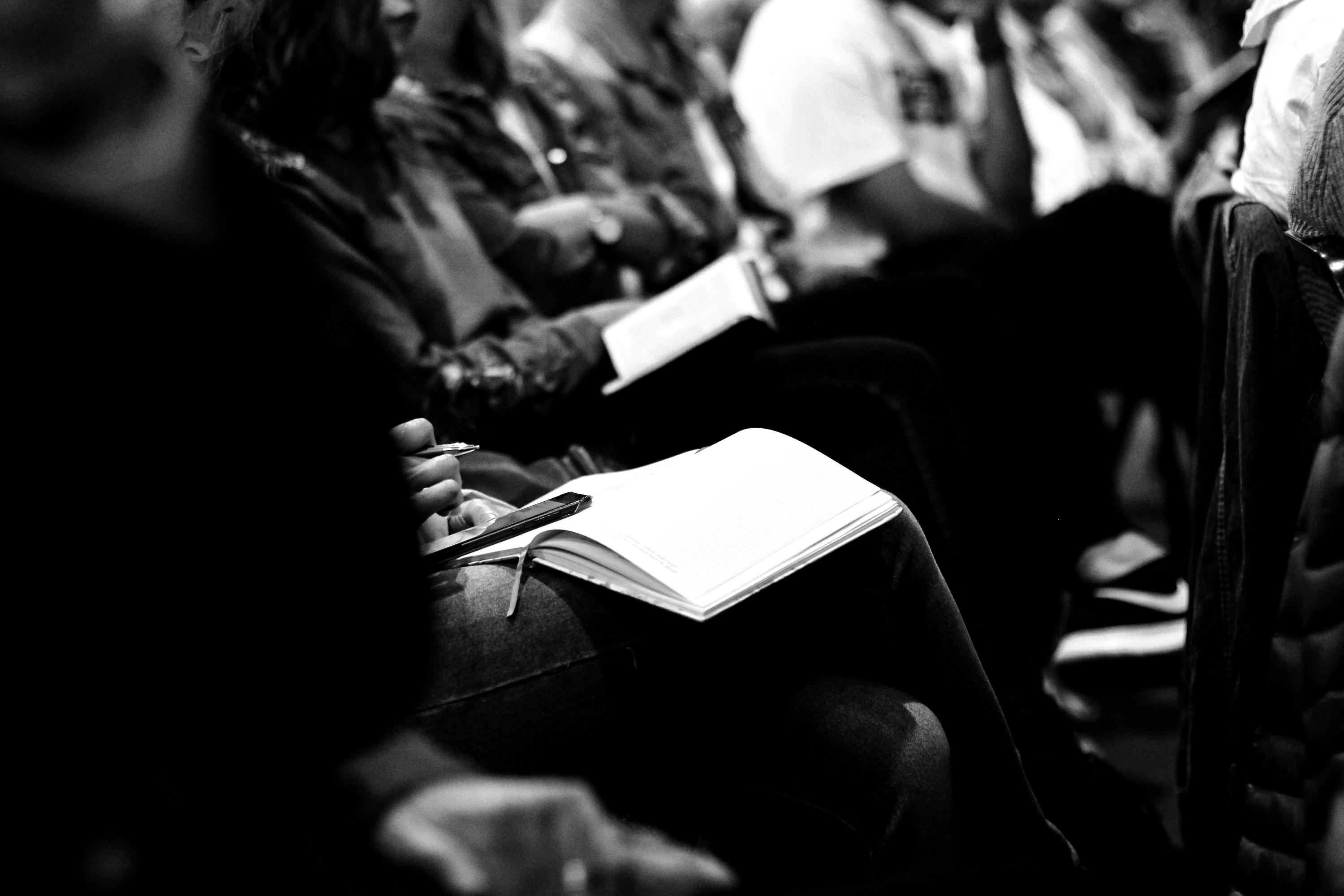 Close-up of professionals writing in notebooks during a specialized training workshop.