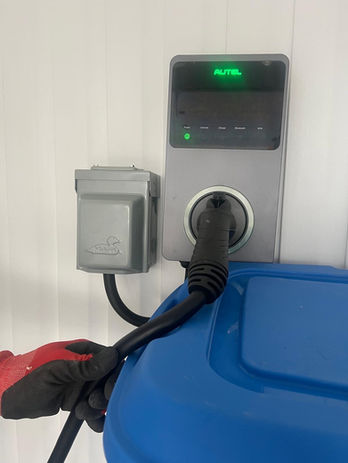 Une prise électrique avec un câble branché, affichant un témoin lumineux.