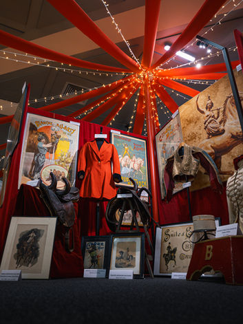 Vue d’ensemble d’un espace de l’exposition L’Ère des écuyères réunissant costumes, selles, affiches anciennes, gravures et objets historiques liés à l’art des écuyères de cirque.