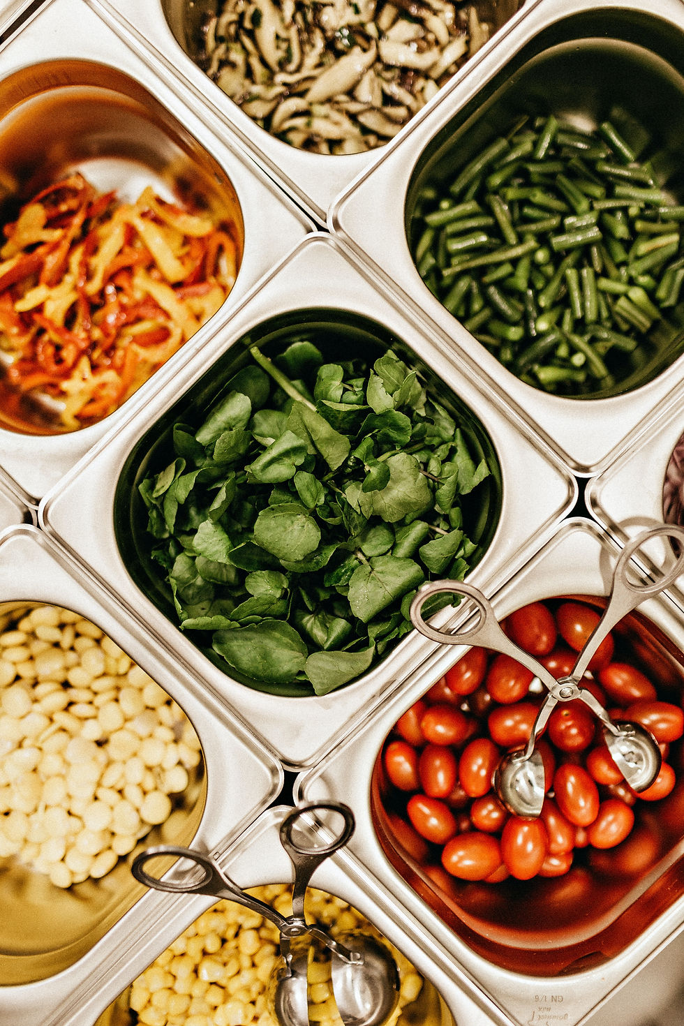 Mixed vegetables in silver chafing dishes.