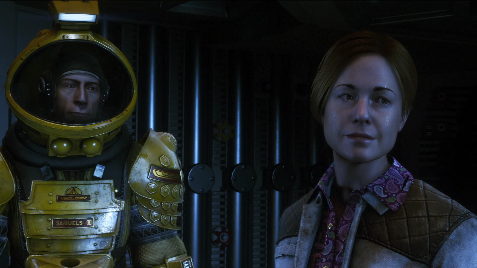 A man in a spacesuit looks forward as a woman in a jacket stares blankly.