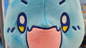 A blue, anime-inspired dinosaur stares forward, mouth agape.
