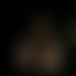 A digital facsimile of Tupac Shakur stands in a dimly lit Japanese buildng.