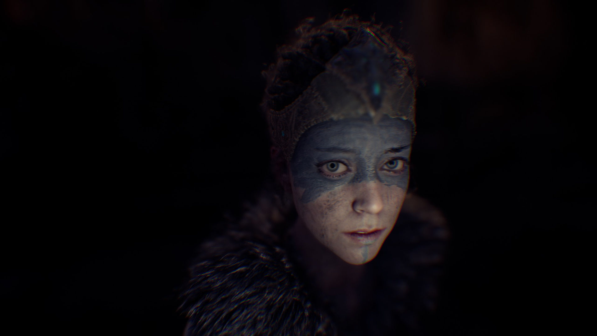 Senua stands in the dark, a close-up on her face reveals she is confused.