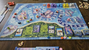 A beautiful board covered in oceanic iconography, topped with a multitude of tokens, dice, and cards.