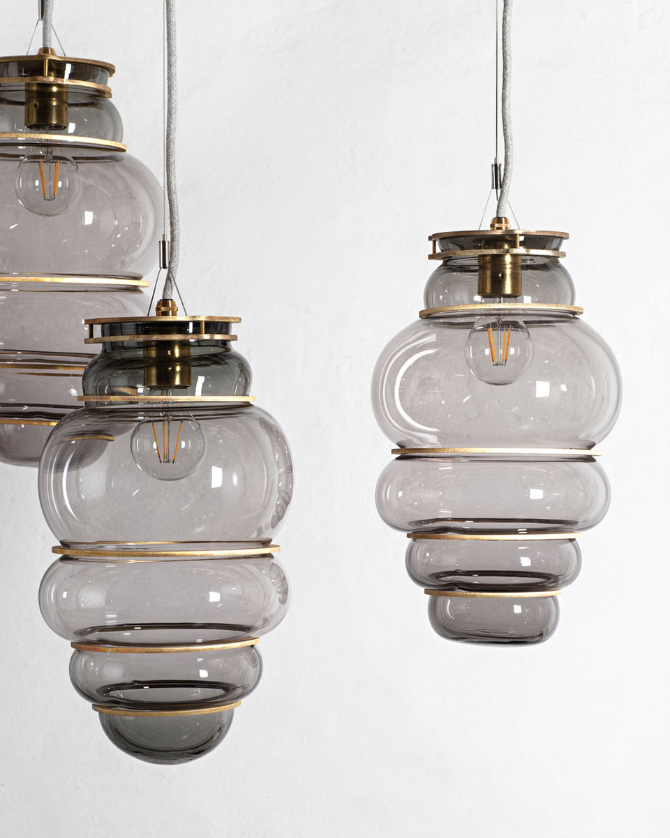 Handcrafted glass pendant lamps by Stoft Studio featuring brass details and soft curves, showcasing elegant Scandinavian lighting design.