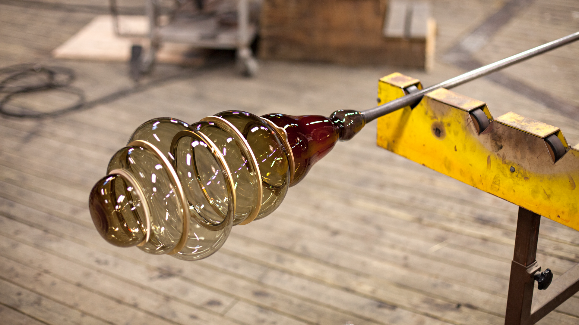 Glassblowing process by Stoft Studio showing molten glass formed into a spiral shape, highlighting Scandinavian craftsmanship and design artistry.