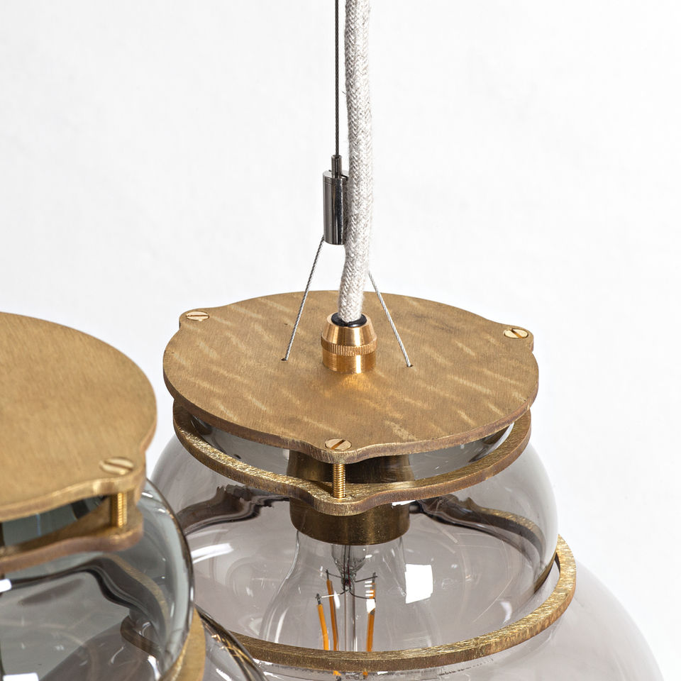 Close-up of Stoft Studio pendant lamp showing brass top detail and glass connection, reflecting Scandinavian lighting design precision and quality.