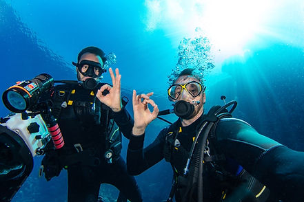 Buddy team photographing a coral head at Manchones after a first dive at MUSA.