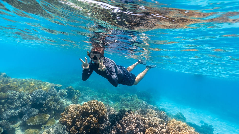 A snorkeling tour boat on bright turquoise Caribbean water off Cancun