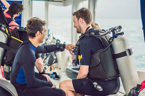 Reunión informativa en barco de Manta Divers Cancun con el instructor y un grupo pequeño; se muestra el equipo de seguridad y la sombra.
