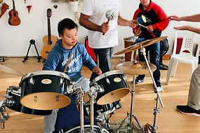 criança com Síndrome de Down tocando bateria 