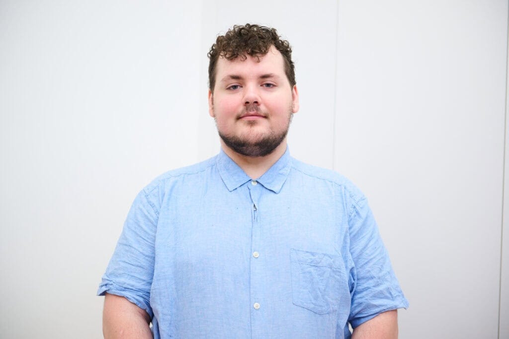 Youth Council member Callum stood in front of a white backdrop.