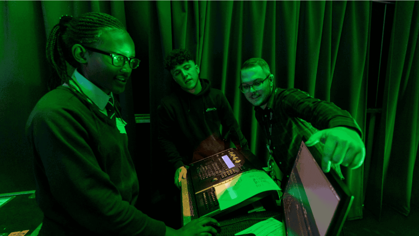 A group of men looking at a monitor screen