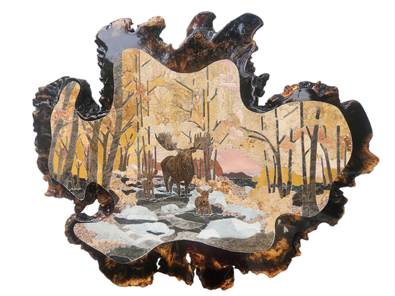 Stone-cut artwork depicts a moose and calf standing in a snow-covered forest with bare trees and a pink sky, set on an irregularly-shaped slab of Buckeye Burl wood.