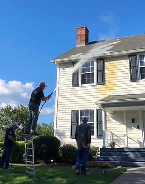 people working on a house pressure washi