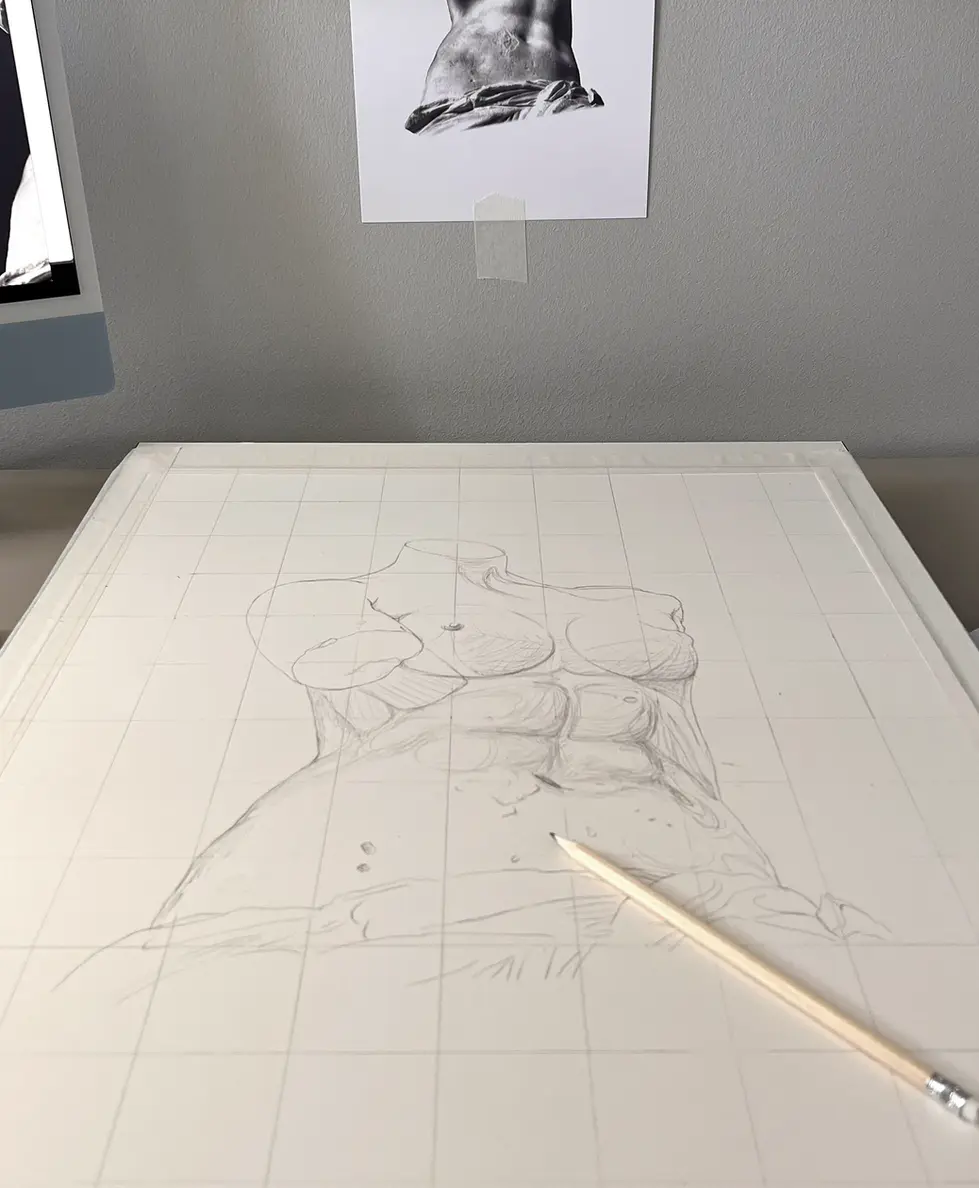 a pencil is on a piece of paper sketching Venus de Milo