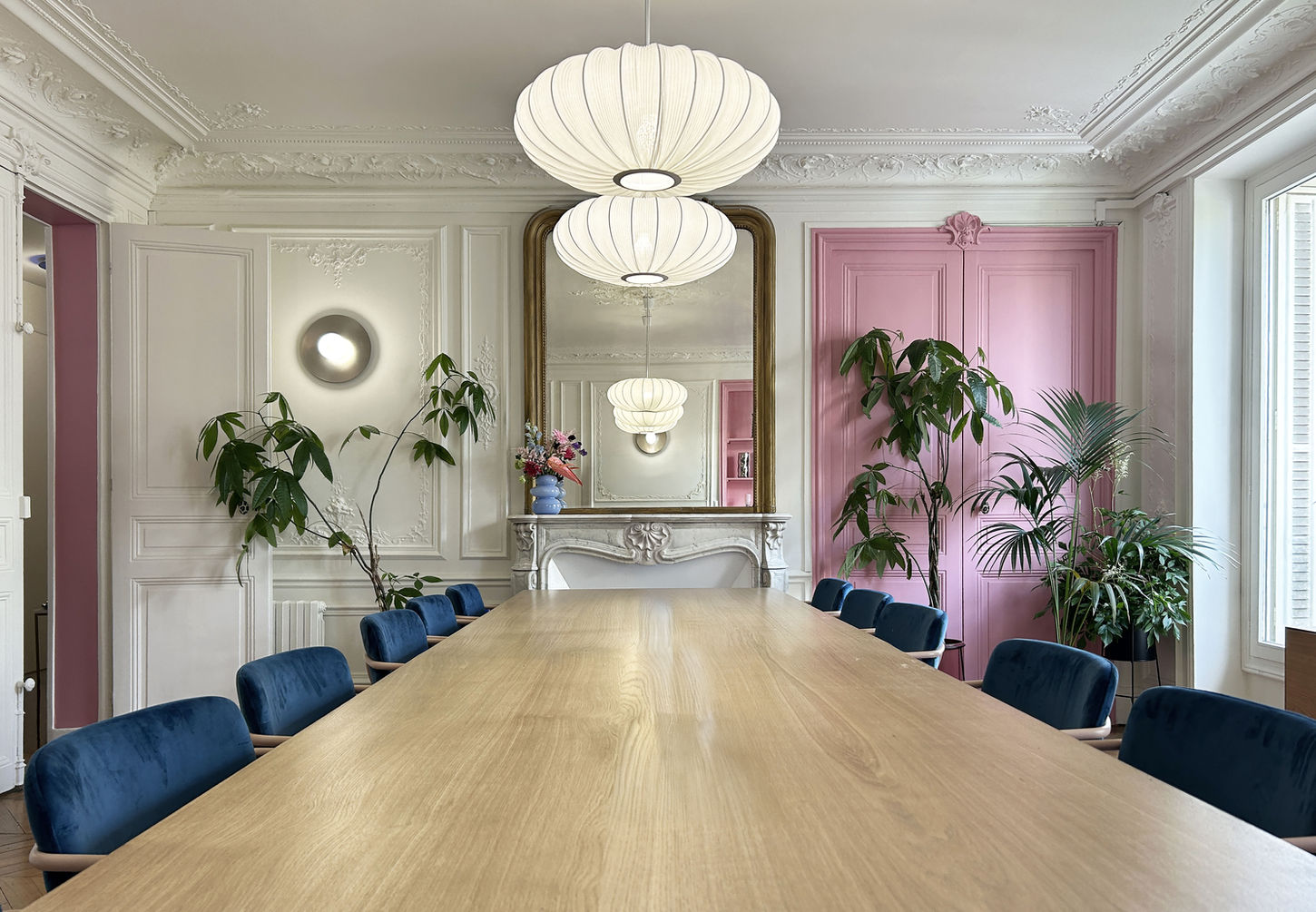 salle de réunion haussmanienne au couleurs pop, enseigne lumineuse et grand table 