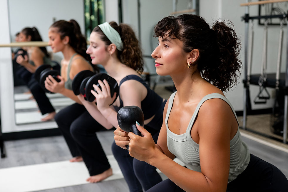 three women performing a squat while holding weights