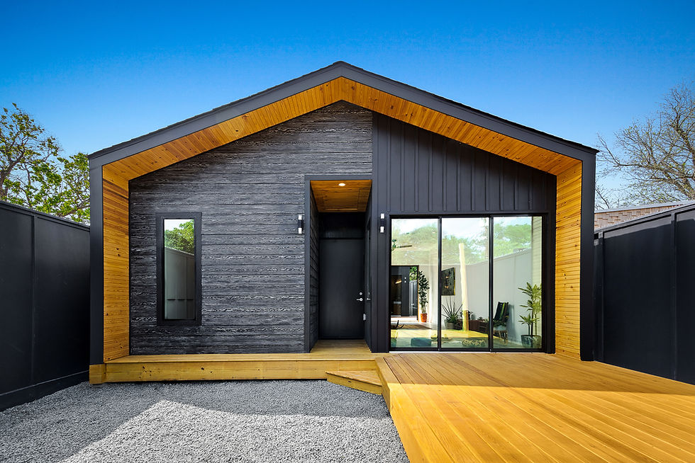 The outside of a home with black sliding, and large windows with natural wood accents on the roof