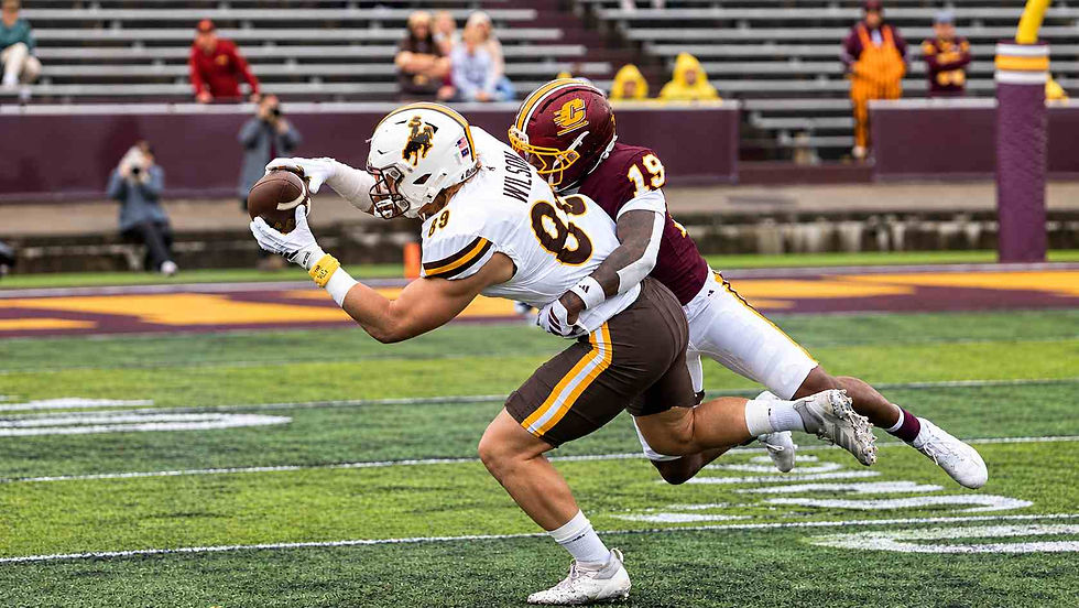 Wyoming tight end Jake Wilson (#89) reaches for the ball while being tackled by a Central Michigan defender during game action at Kelly/Shorts Stadium. Photo courtesy of UW Athletics.