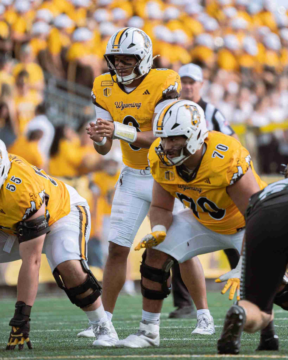 Wyoming quarterback Tyler Hughes (#6) prepares for the snap behind the Cowboys’ offensive line during Wyoming’s 27-10 win over Hawai‘i at War Memorial Stadium. Photo by Donny Felcsuti, PokesNews.com.