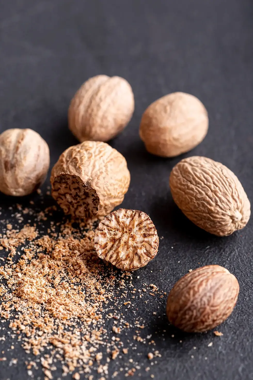 Ground nutmeg beside whole nutmeg