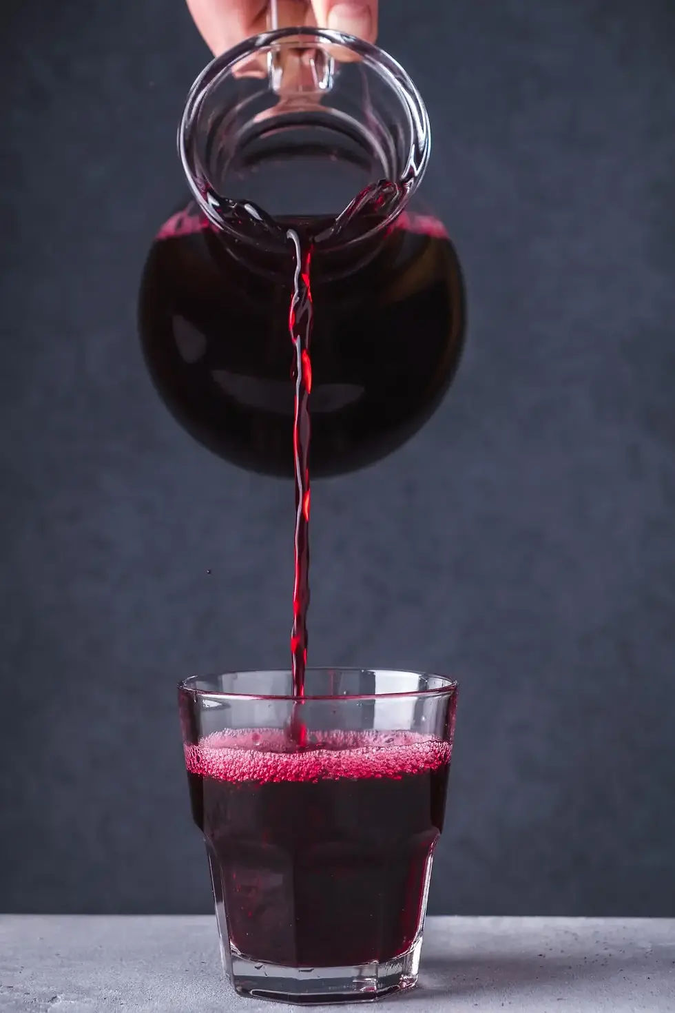 Black currant juice being poured into a glass