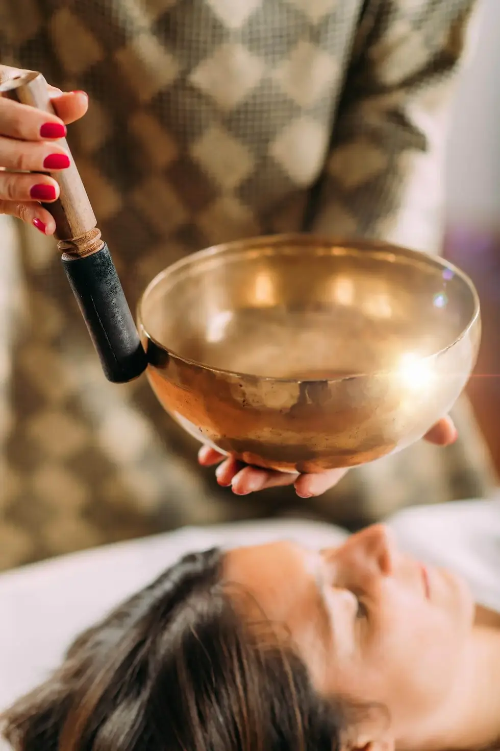 Singing bowl held above a person lying down