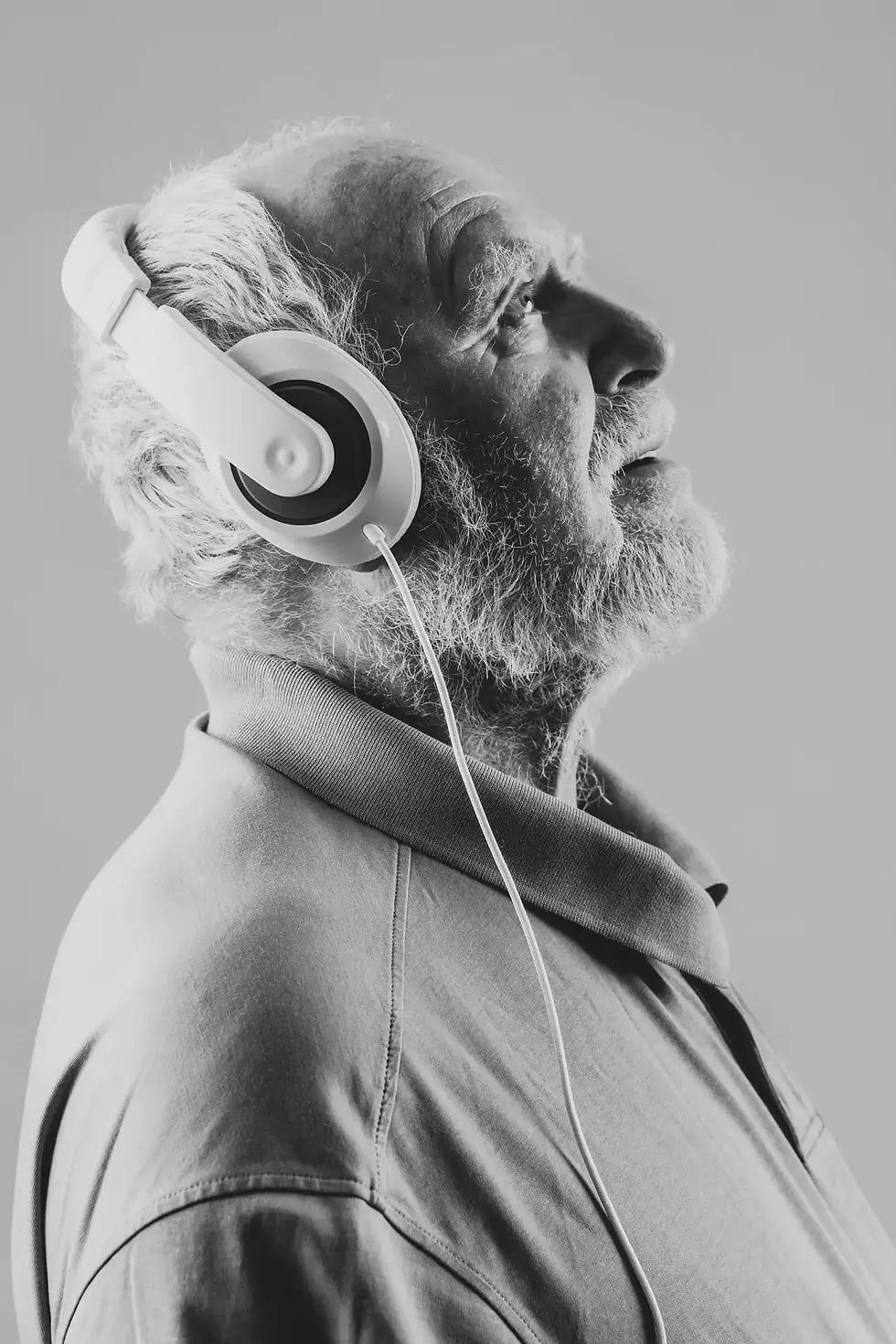 Older man wearing headphones with eyes closed
