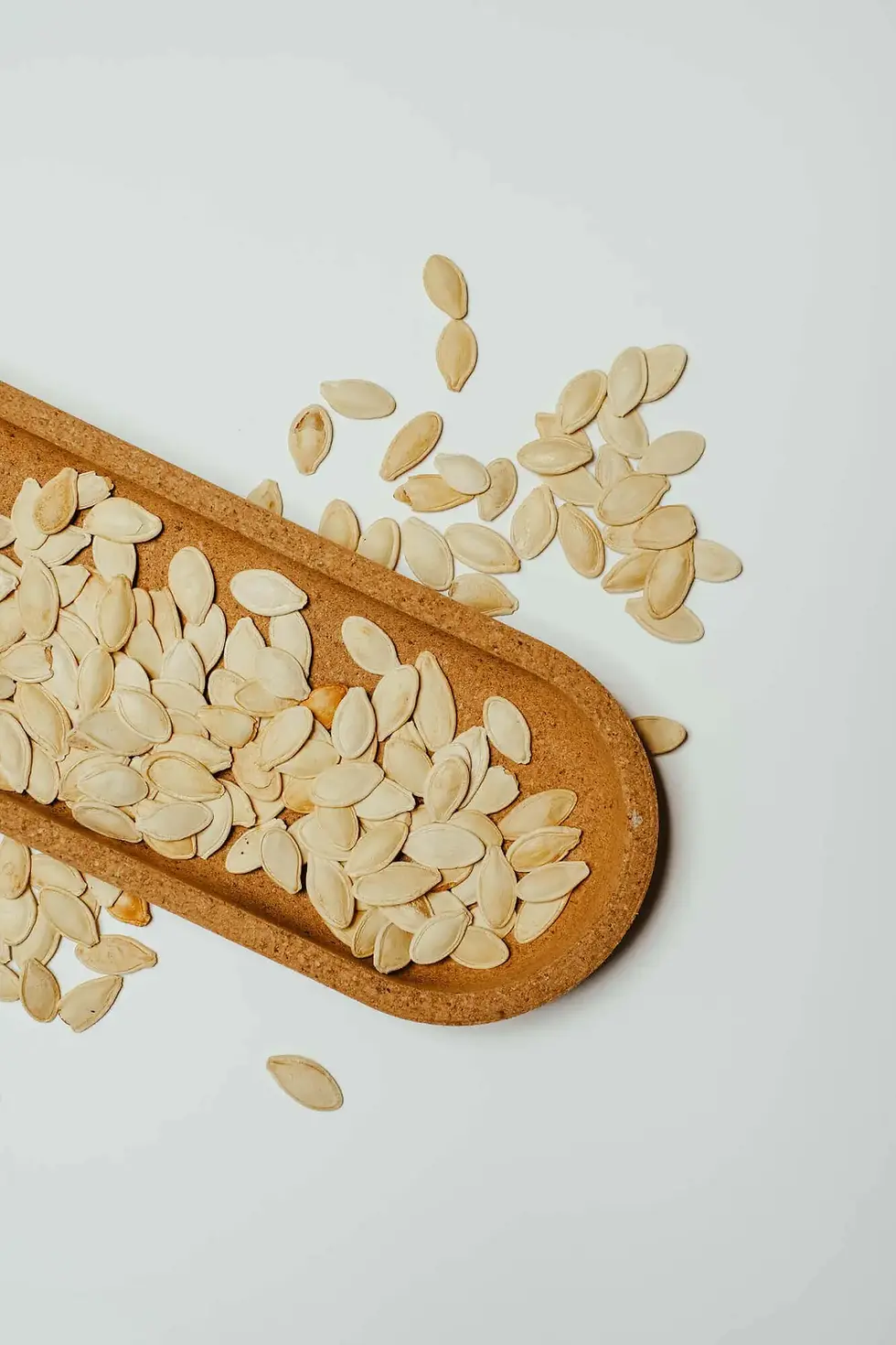 Pumpkin seeds in a spoon and bowl
