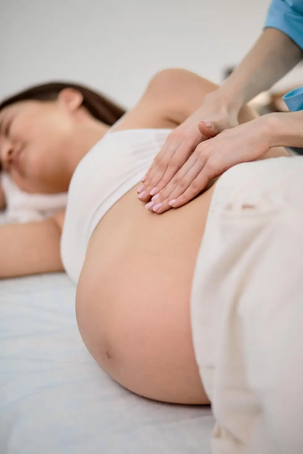 Pregnant person lying on the side receiving massage