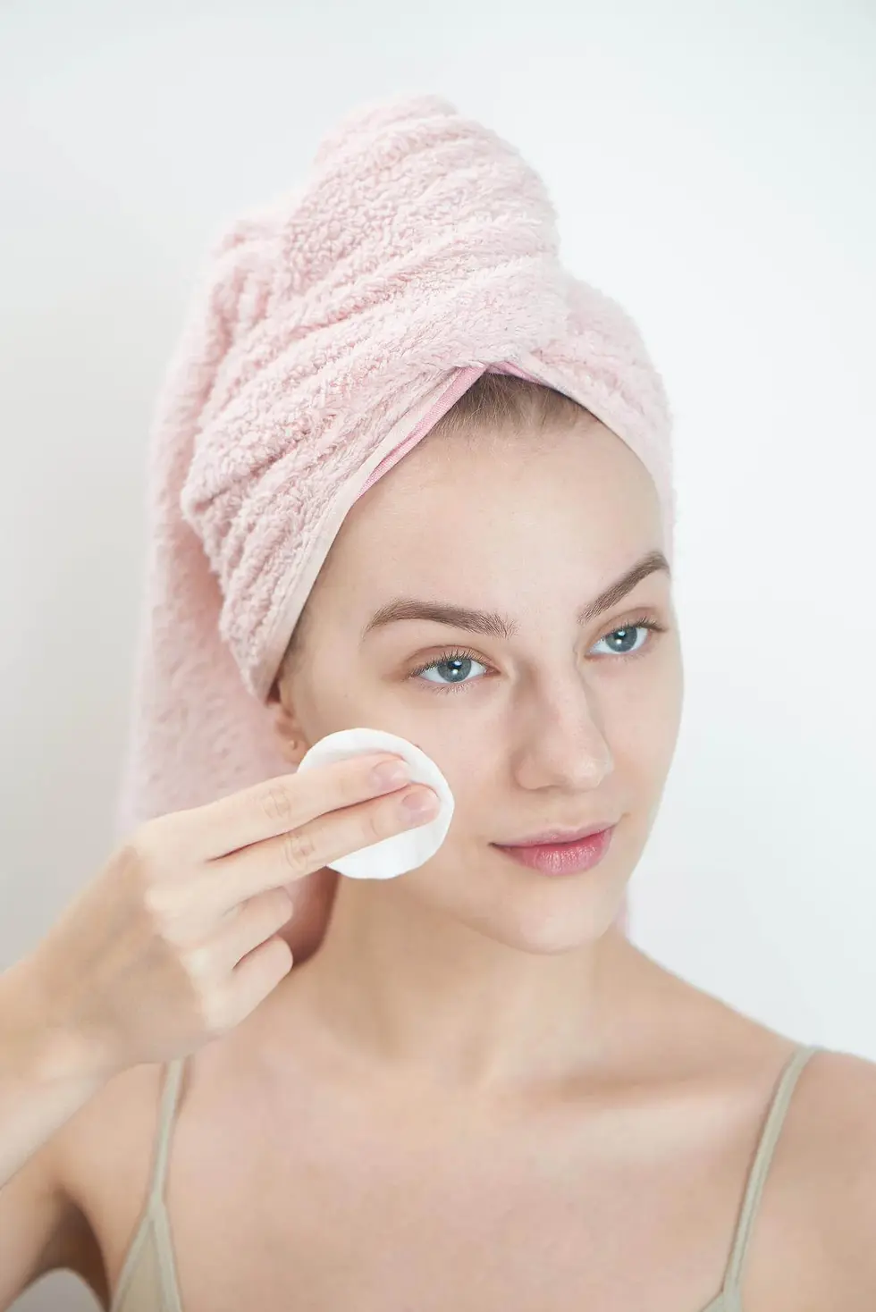 Woman using a cotton pad with makeup remover
