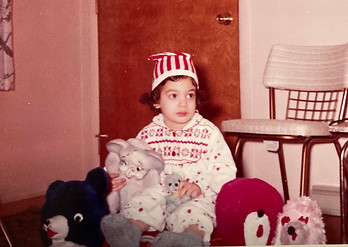 nervous-looking child in pajamas with striped santa hat circa 1962