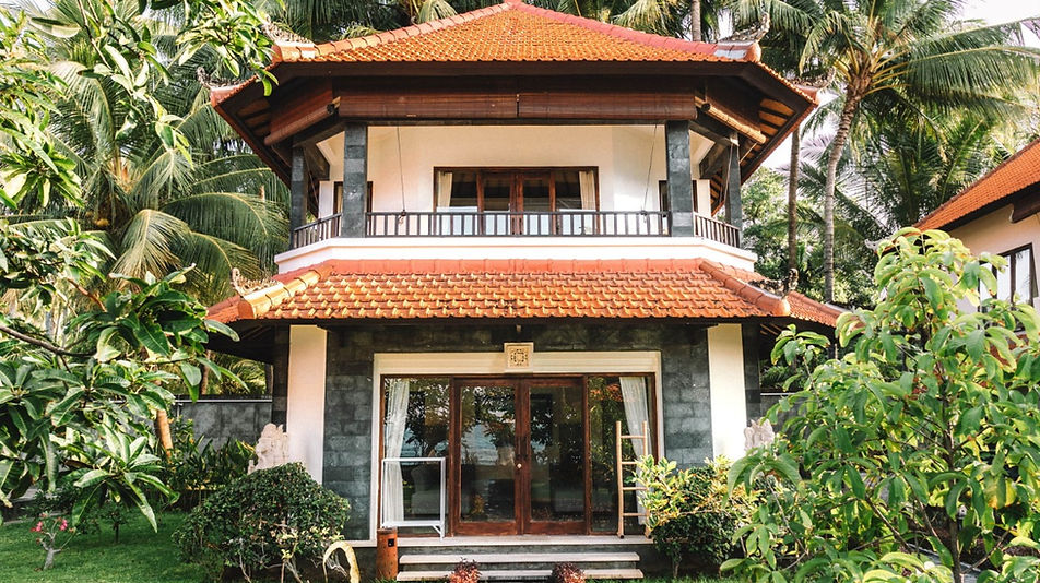 Bungalow Keluarga dua lantai dengan arsitektur tradisional Bali, balkon lantai atas, dan taman tropis di Bondalem Beach Club, Bali Utara.