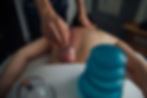 Person relaxing in a minimalist wellness studio with soft ambient lighting and organic textures