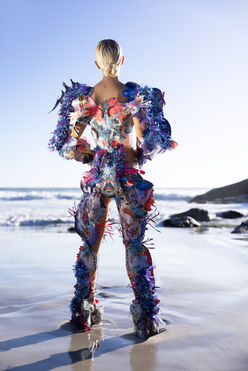 Chelsea Jean Lamm & Ashley Elizabeth Lamm – ITS Academy Contest 2024 & GO! 2025 Borderless Exhibition
Pushing the boundaries of avant-garde couture and wearable art, Chelsea Jean Lamm & Ashley Elizabeth Lamm present a groundbreaking piece for the ITS Academy Contest 2024 and the GO! 2025 Borderless Exhibition in Trieste, Italy. This visionary creation embodies the fusion of sustainability, craftsmanship, and conceptual fashion, redefining the future of high-end design.
Crafted from reclaimed print media, dead-stock silks, and precision embroidery, the piece explores themes of cultural identity, transformation, and borderless expression. With intricate analogue collage techniques, laser-cut detailing, and sculptural silhouettes, it challenges the limits of fashion as both art and statement.
Featured in two of Europe’s most prestigious platforms for emerging fashion innovation, this creation represents a new era of couture, where eco-conscious materials, avant-garde aesthetics, and high fashion craftsmanship converge.
Look Goura Victoria, Echoes of Eden Summer 2023 by Chelsea Jean Lamm in collaboration with Ashley Elizabeth Lamm, modeled by Max Penny from Ice Models, photographed by Nina Zimolong in Cape Town, South Africa, Mask by Carina Shoshtary