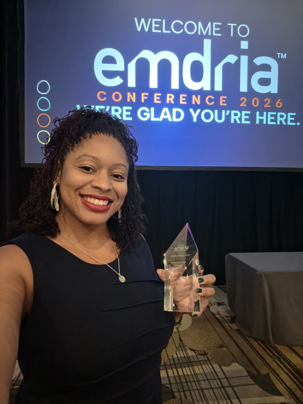 Dr. Arielle Jordan holding her 2026 EMDRIA Emerging Leader Award