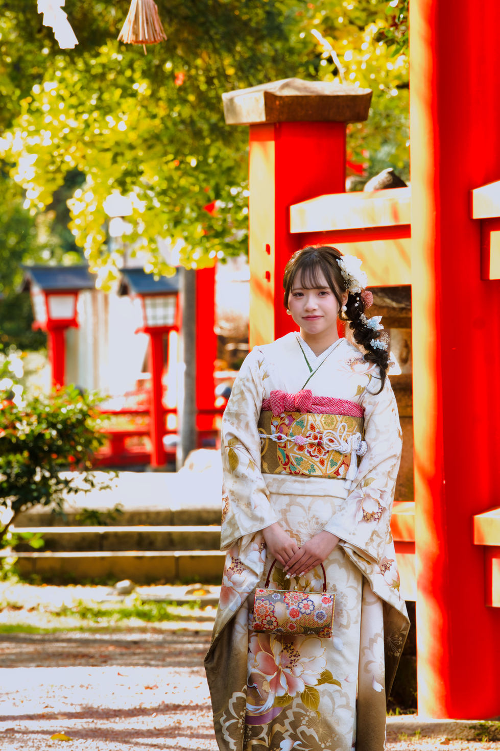 成人式ロケ撮影で着物を着た女性が赤い鳥居の前に立つ
