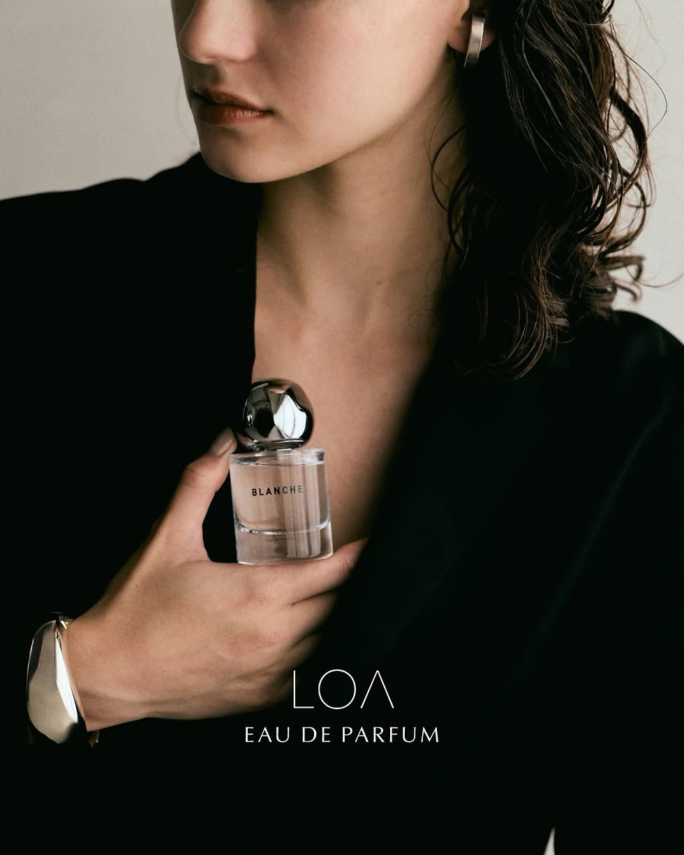 LOA EAU DE PARFUM BLANCHEのボトルを持つ女性