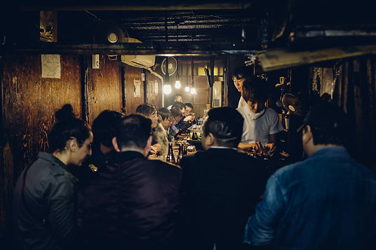 A bar full of people at night in Tokyo
