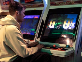 A young man playing vintage arcade games in Akihabara, Tokyo