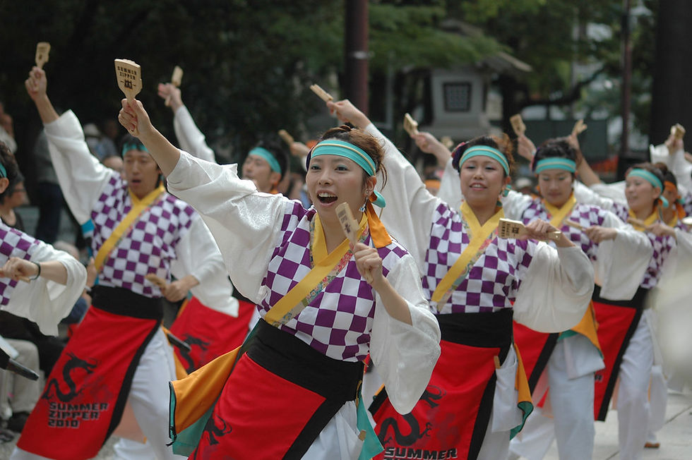 Yosakoi dancers in colorful traditional clothing holding up clappers called naruko